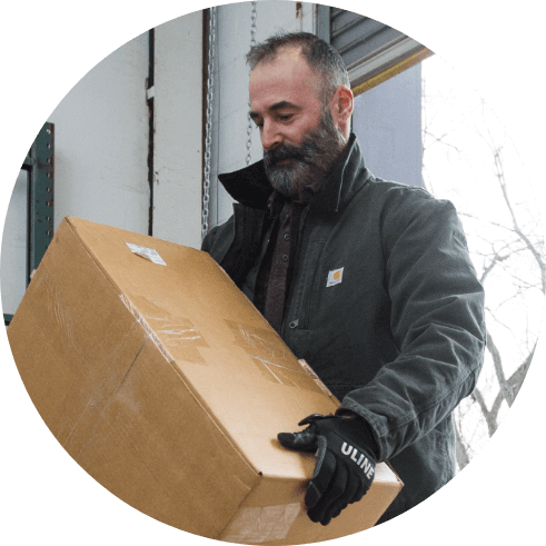 man carrying a cardboard box in a warehouse