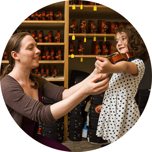 woman help girl with instrument sizing