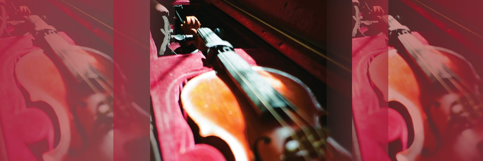 A violin resting in a red-lined case.