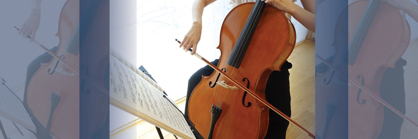 Person playing cello beside a music stand with sheet music in a bright room
