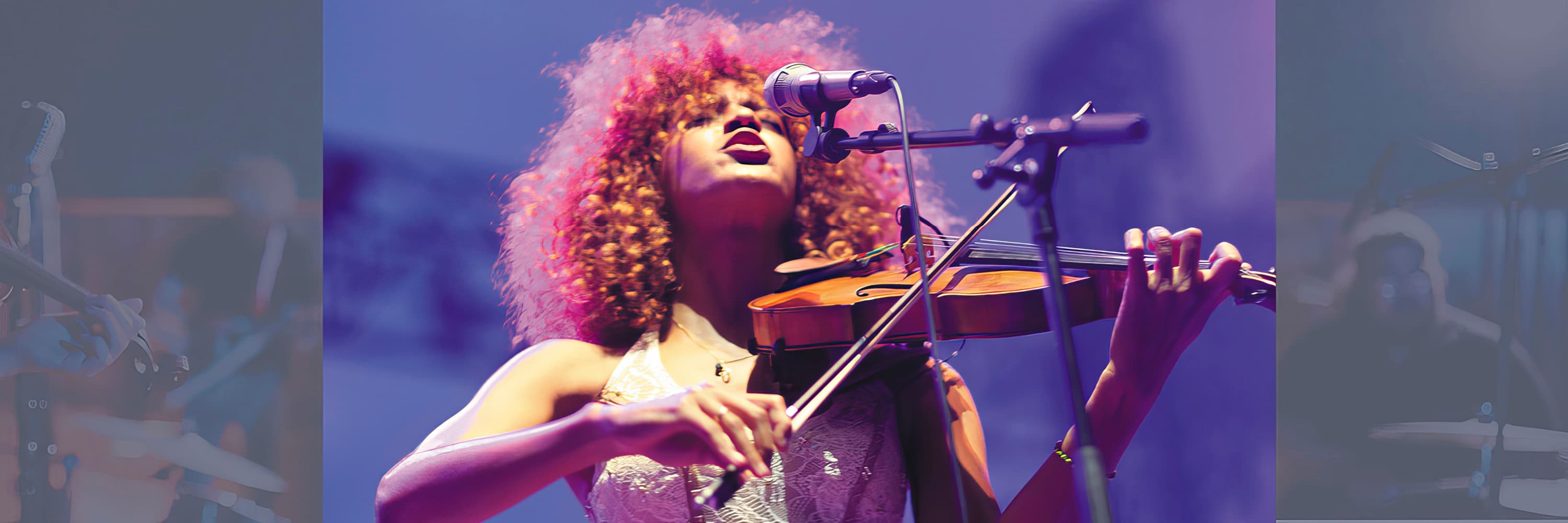 Female musician playing the violin and singing into a microphone on stage.
