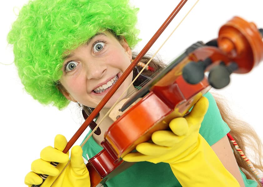 Girl with green wig and yellow gloves playing the violin
