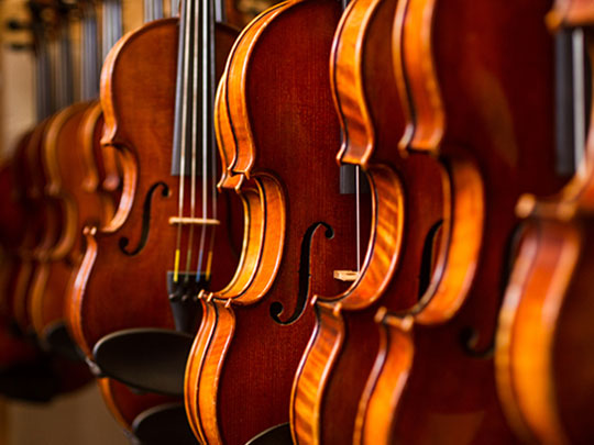 violins hanging on a rack