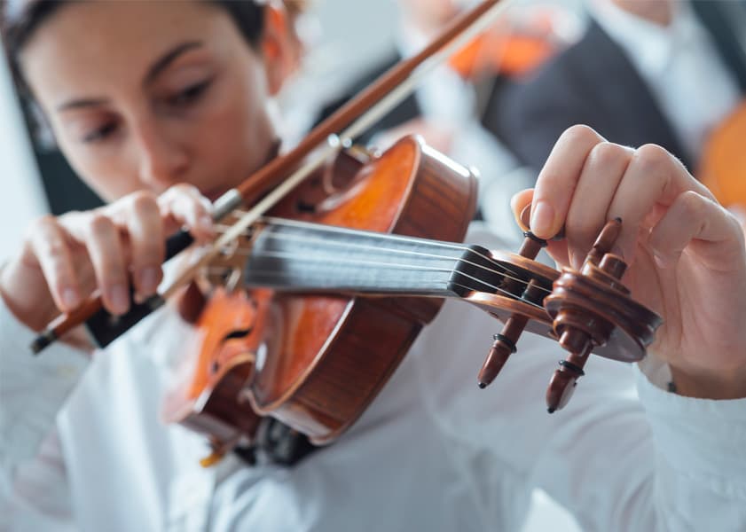 woman tuning a violin