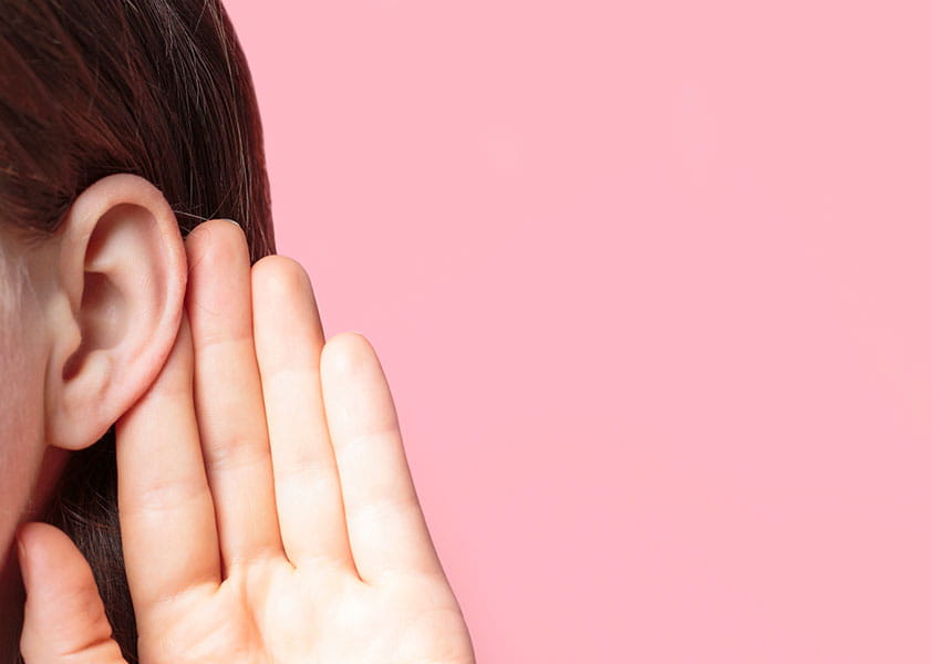 person listening with hand cupping ear