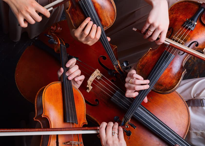 extreme closeup of three violins and a cello