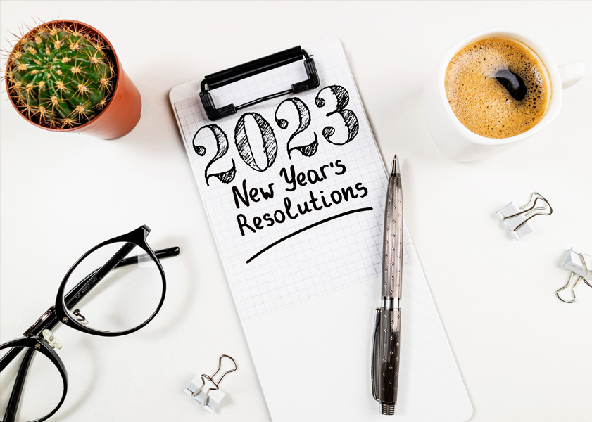 notepad and pen. notepad has 2023 resolutions written on it.