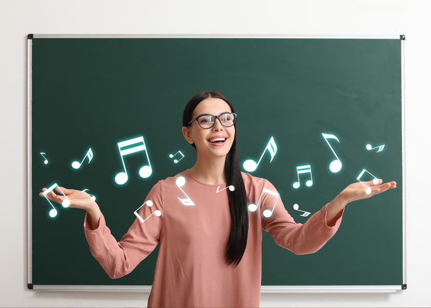 woman in front of blackboard with music notes floating in front of her