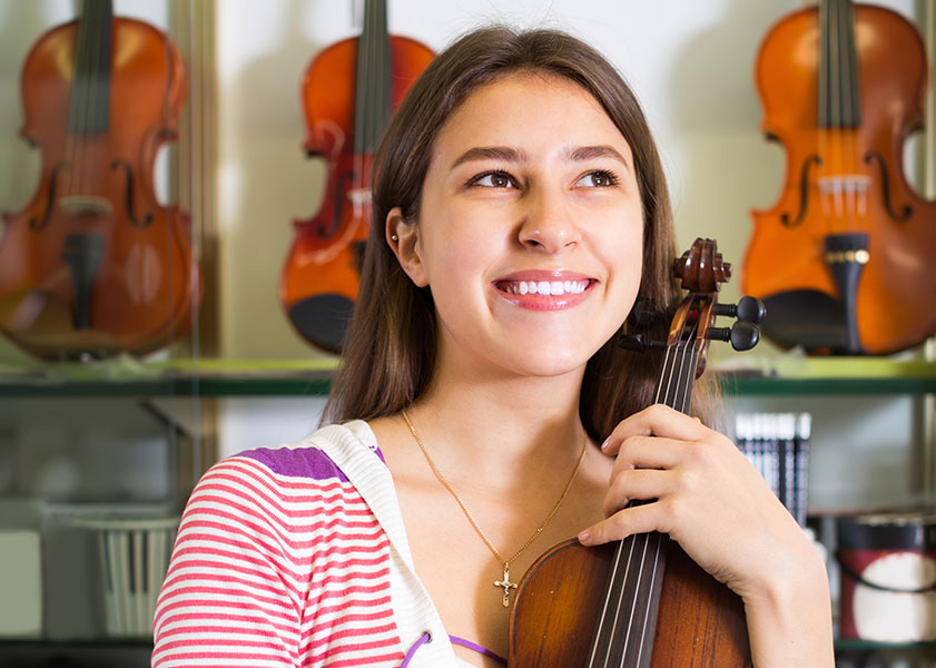 smiling girl holding violin