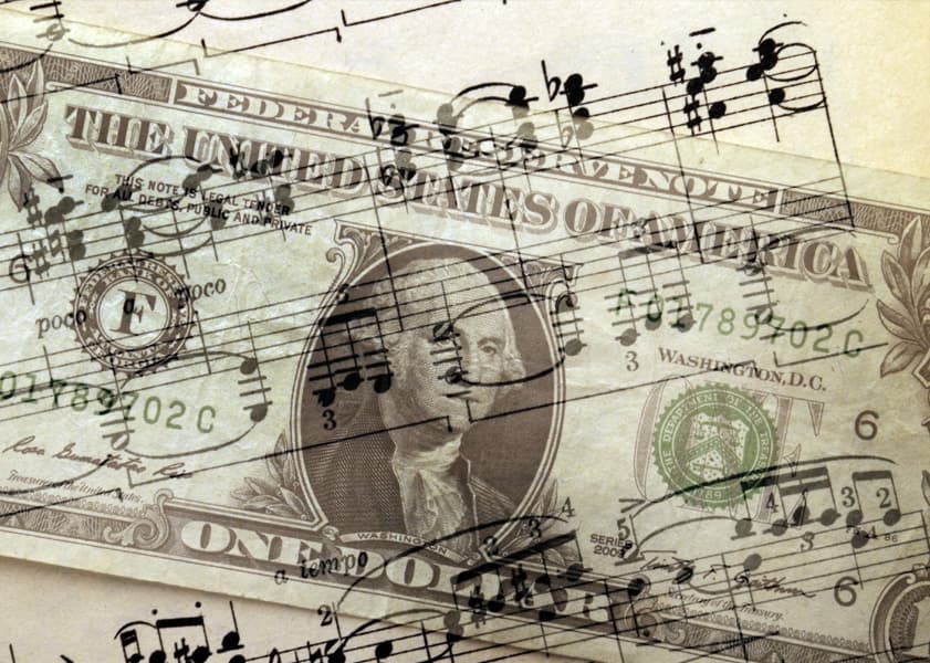 One dollar bill with musical scales overlaid