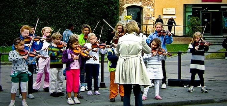 Violin teacher instructs a group of children
