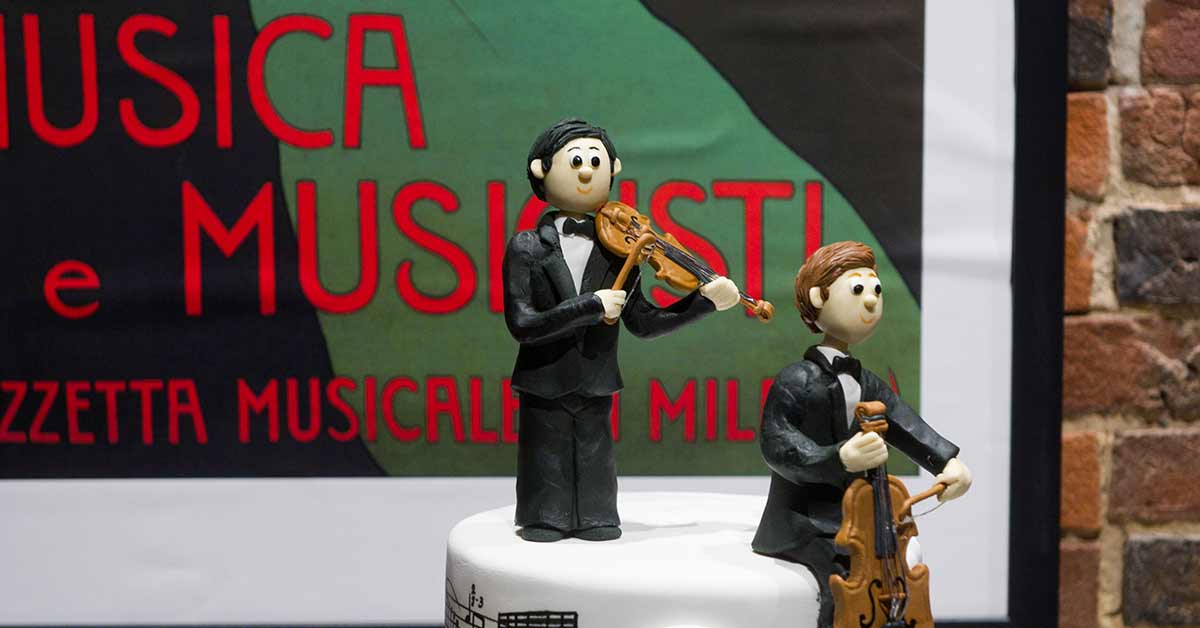 Wedding cake topper of two people playing string instruments