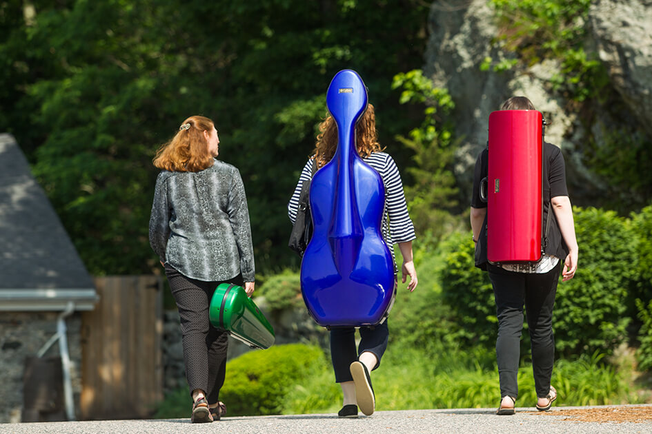 Three woman carry instrument cases